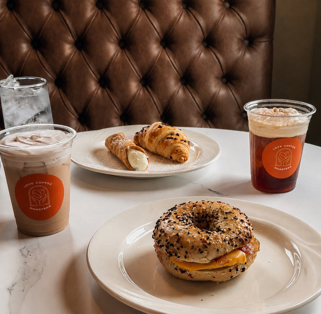 Breakfast bagel sandwich, pastries, and drinks at Love Coffee Roasters